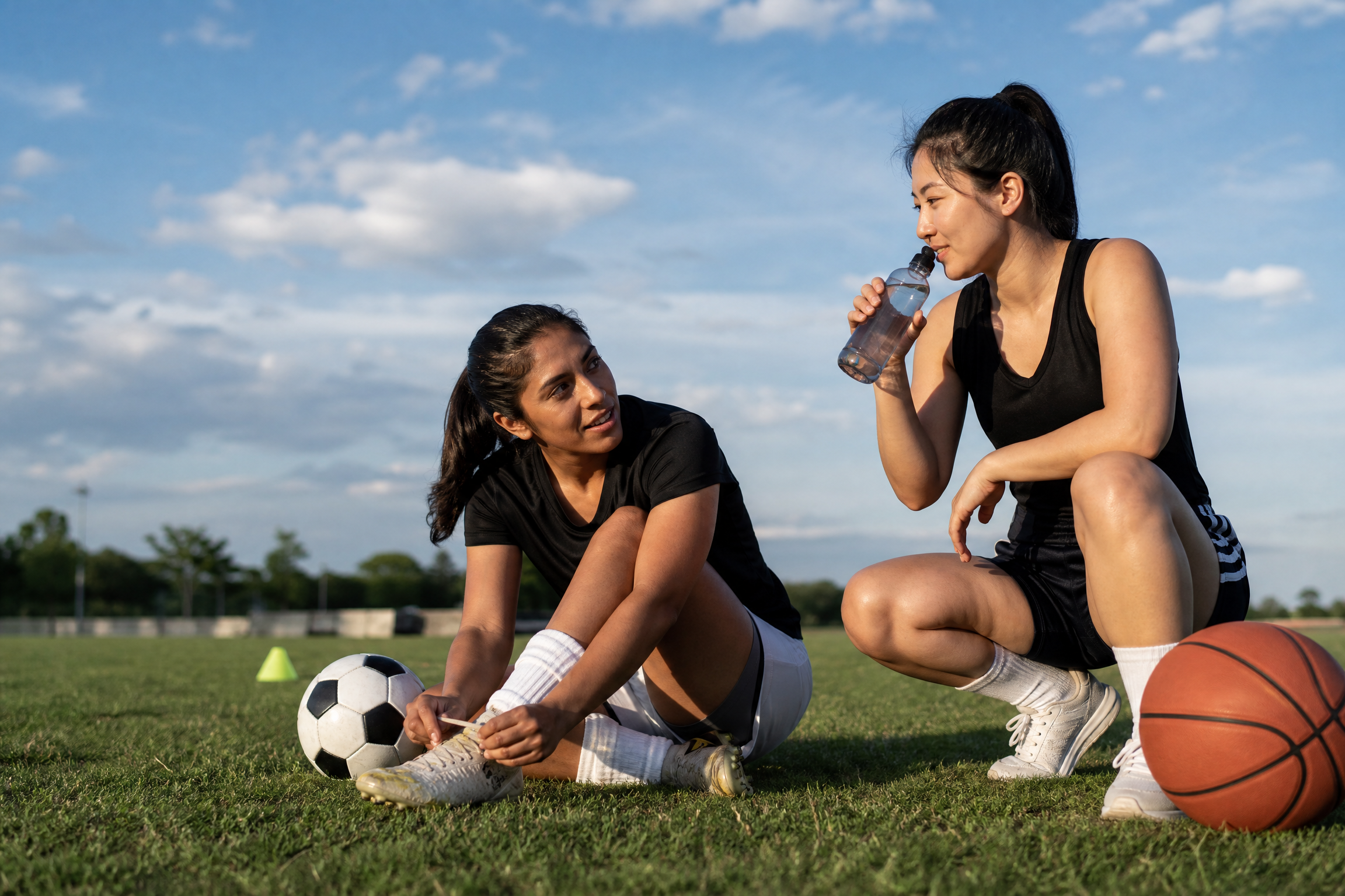 Two female athletes recovering and connecting after practice